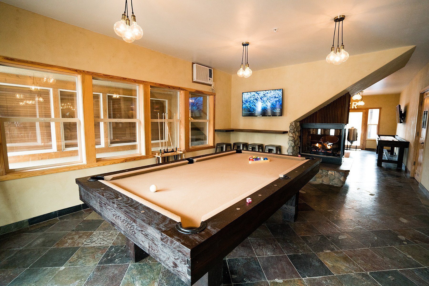 Eureka Peak Brewing Co. — game room with pool table, stone fireplace and lounge seating