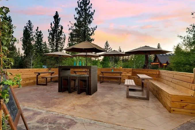 Eureka Peak Brewing Co. — outdoor patio at sunset with string lights and Sierra Nevada pine backdrop