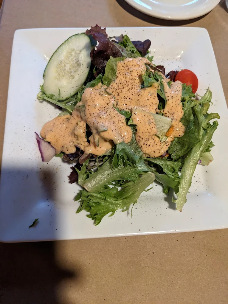 Iron Door Restaurant — house salad with tomato and cucumber on white square plate